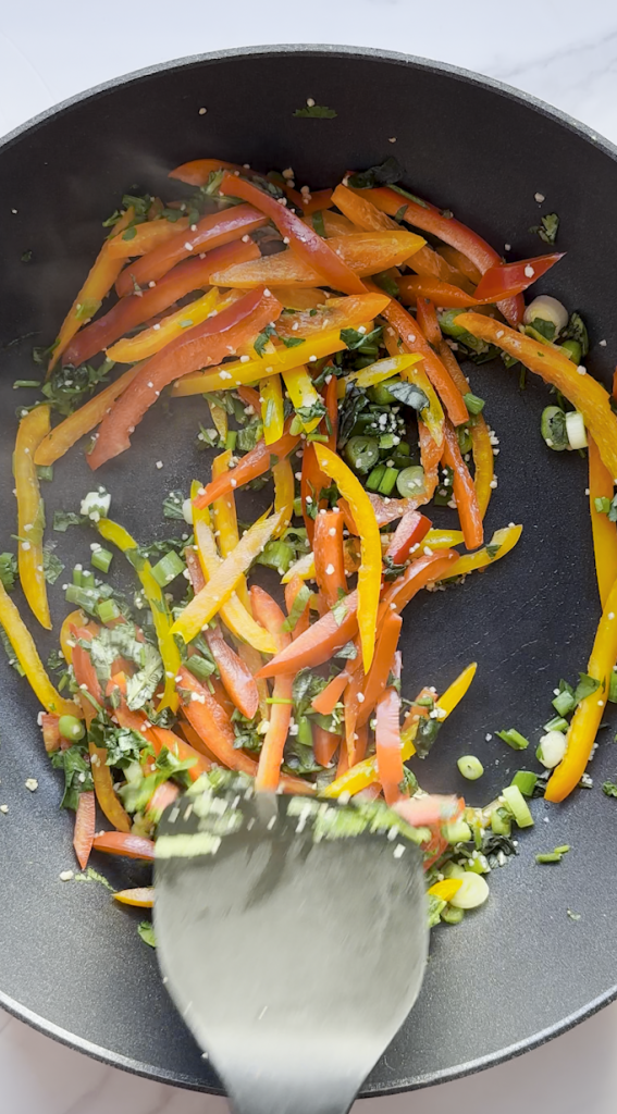 sliced bell peppers with cilantro, basil, and green onions added with garlic minced sautéed